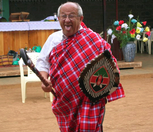 Don Ennio in Africa che scherza indossando abiti tipici di antiche tribù
